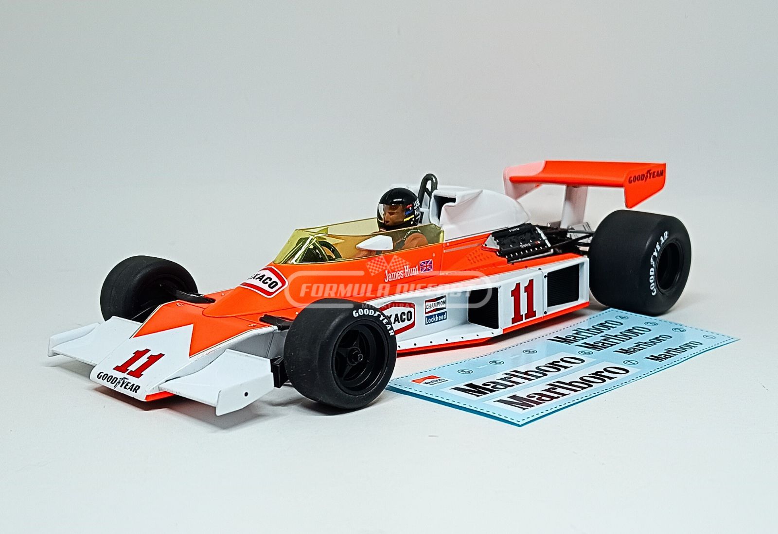 Miniatura de carro McLaren M23 #11 James Hunt, 1º lugar GP da França, Campeão Mundial F1 1976, escala 1:18, marca MCG